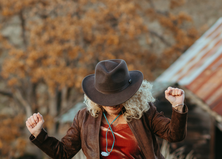woman wearing a hat celebrating