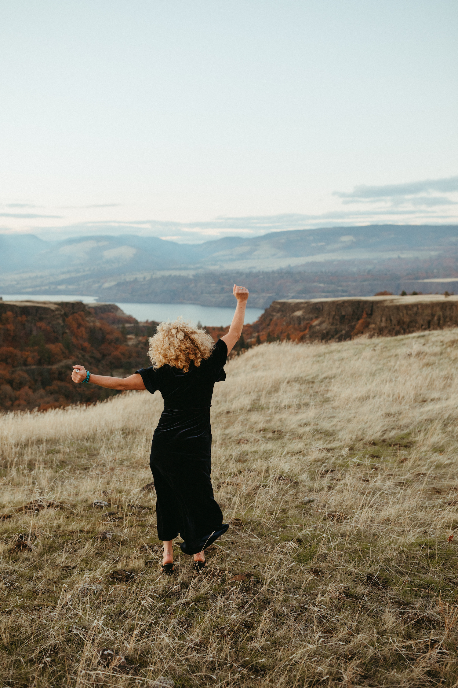 woman in dress walking overlooking the mountainscape